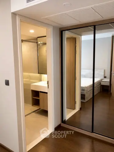 Modern apartment interior with mirrored closet and bathroom view