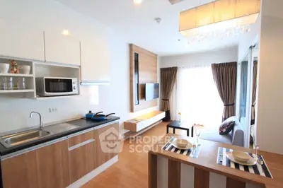 Modern open-layout kitchen and living room with stylish decor and natural light.