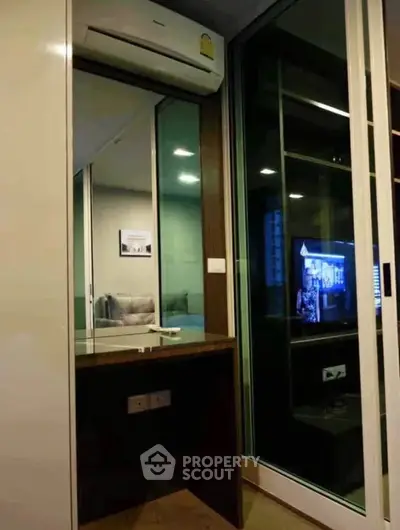 Modern apartment interior with air conditioning and glass partition, showcasing a cozy living space.