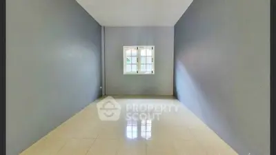 Spacious empty room with tiled flooring and a window, perfect for customization.