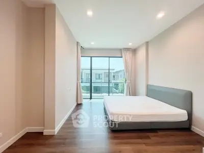 Spacious bedroom with large window and modern design in a luxury apartment.