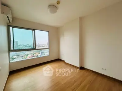 Spacious empty room with large window offering stunning city views, perfect for customization.