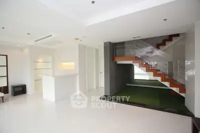 Spacious modern living room with sleek staircase and minimalist design