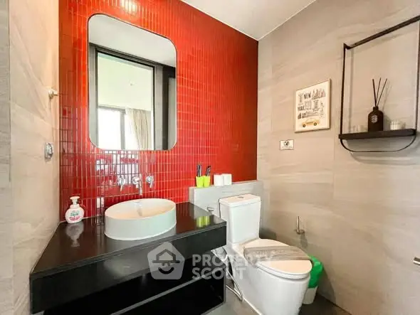 Modern bathroom with red accent wall and sleek fixtures