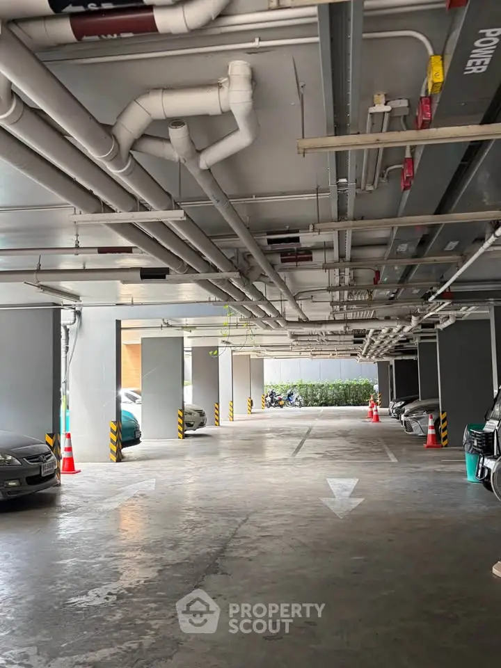 Spacious indoor parking area with multiple cars and clear directional arrows.