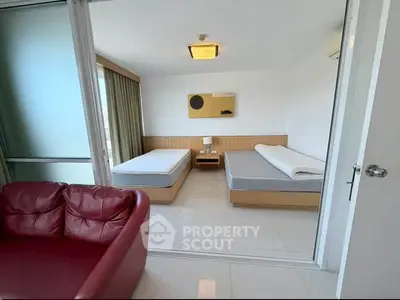 Spacious bedroom with twin beds and modern decor in a bright apartment.