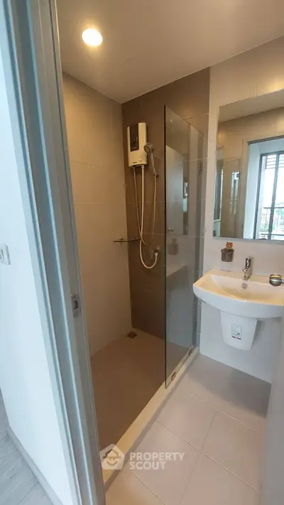 Modern bathroom with glass shower and sleek fixtures in a contemporary apartment.