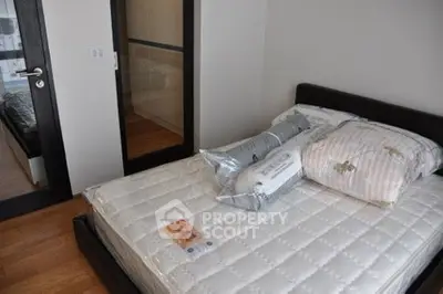 Modern bedroom with sleek design and hardwood floors, featuring a comfortable bed and stylish decor.
