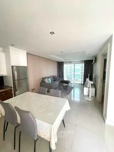 Spacious modern living room with dining area and balcony view
