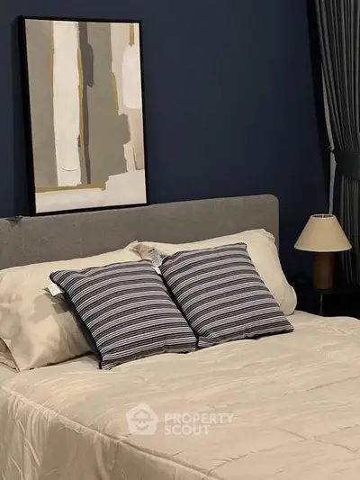 Cozy bedroom with modern decor and stylish artwork, featuring a comfortable bed and elegant lighting.