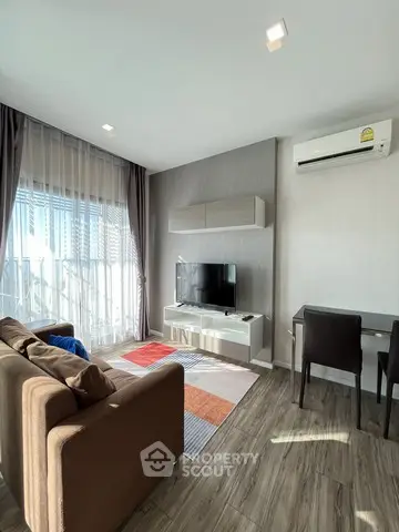 Modern living room with stylish decor, featuring a cozy sofa, flat-screen TV, and elegant dining area.