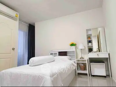 Cozy bedroom with modern decor and natural light, perfect for relaxation.