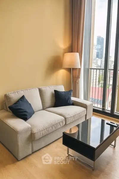 Modern living room with cozy sofa and city view through large windows.