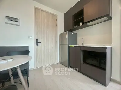 Modern kitchen with sleek cabinetry and compact dining area in a stylish apartment.