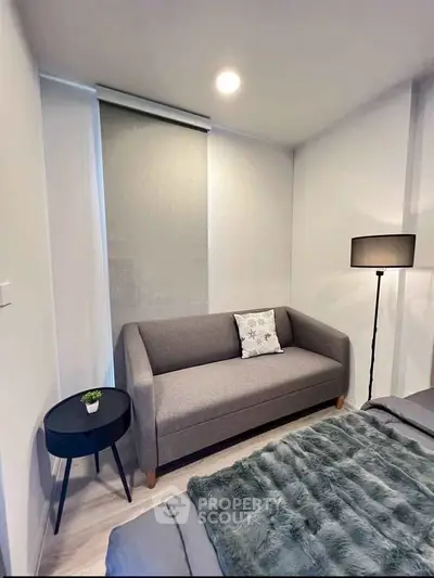 Cozy bedroom with modern gray sofa and stylish decor