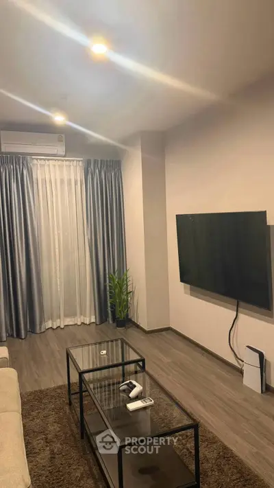 Modern living room with sleek decor, wall-mounted TV, and elegant curtains.