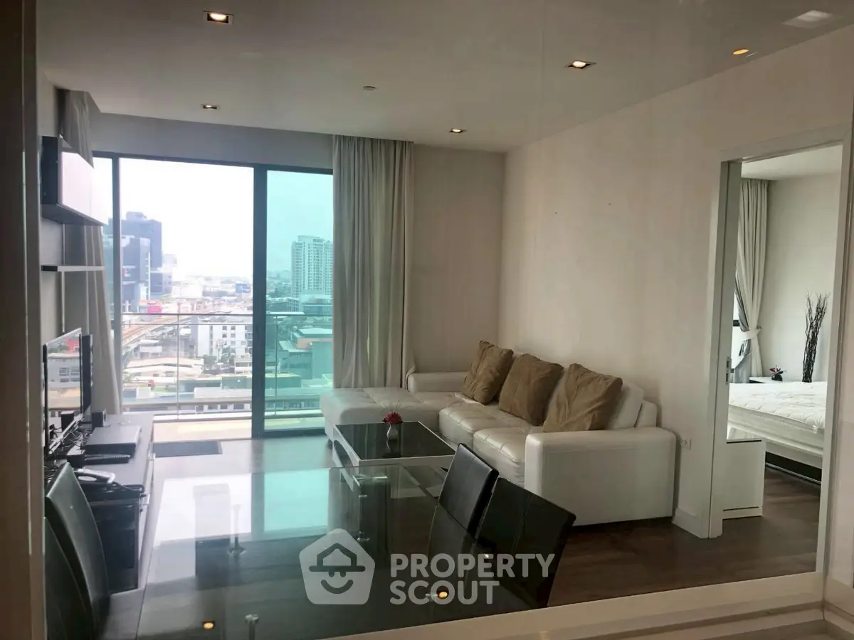 Modern living room with city view, sleek furniture, and open layout in a high-rise apartment.