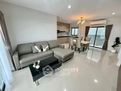 Modern open-layout living room with sleek furniture and dining area, perfect for contemporary living.
