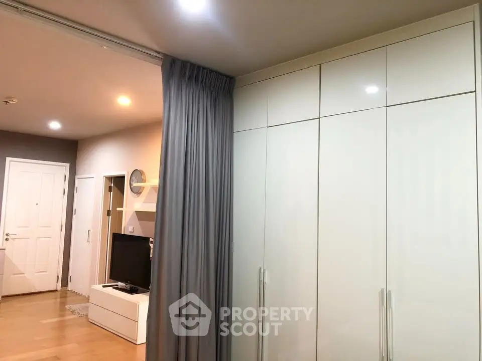 Modern apartment interior with sleek wardrobe and cozy living area