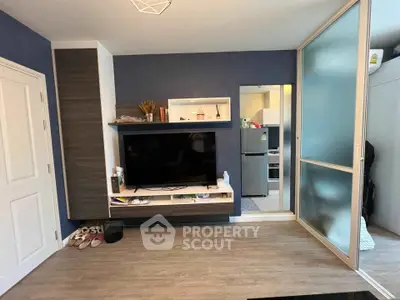 Modern living room with sleek TV unit and sliding glass door to kitchen