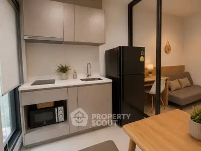 Modern compact kitchen with sleek cabinetry and black fridge in cozy apartment