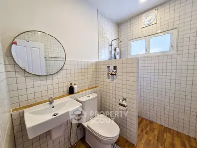 Modern bathroom with stylish tile design and wooden flooring