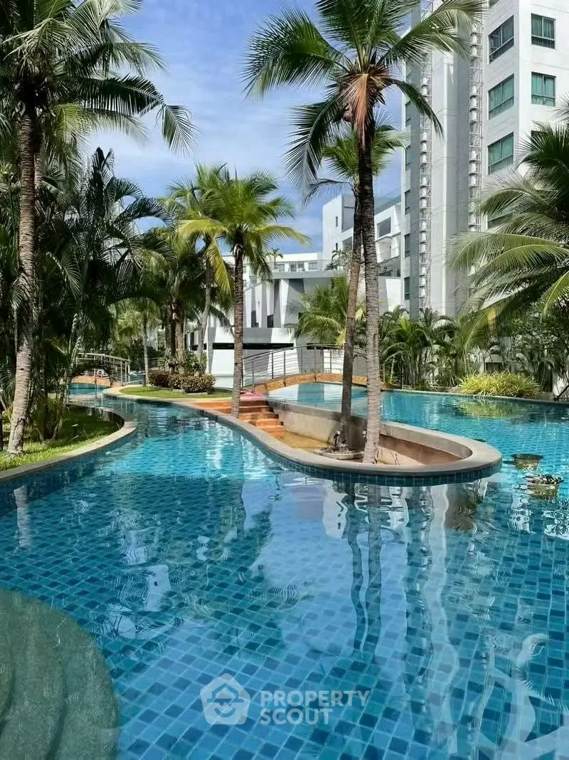 Luxurious tropical pool area with palm trees and modern architecture.