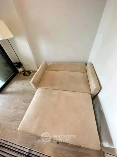 Modern living room with stylish beige sofa bed and elegant floor lamp, perfect for cozy relaxation.
