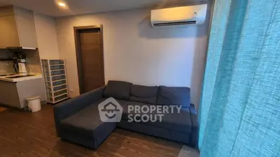 Cozy living room with L-shaped sofa and air conditioning, perfect for relaxation.