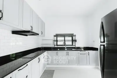Modern kitchen with sleek black countertops and white cabinetry