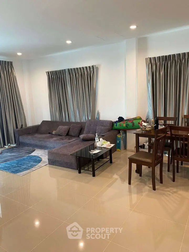 Spacious living room with modern furniture and dining area, perfect for family gatherings.