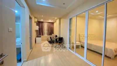 Modern apartment interior with bedroom and dining area, featuring sleek design and ample lighting.
