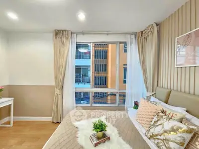 Cozy bedroom with stylish decor and large window offering natural light