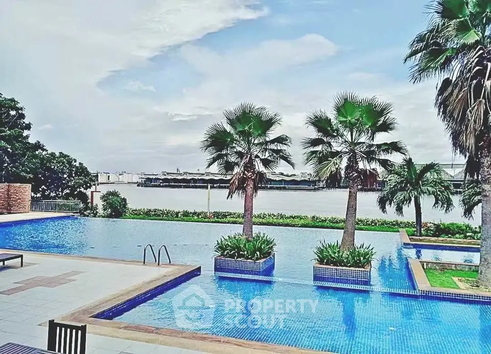 Luxurious waterfront pool with stunning views and palm trees, perfect for relaxation and leisure.
