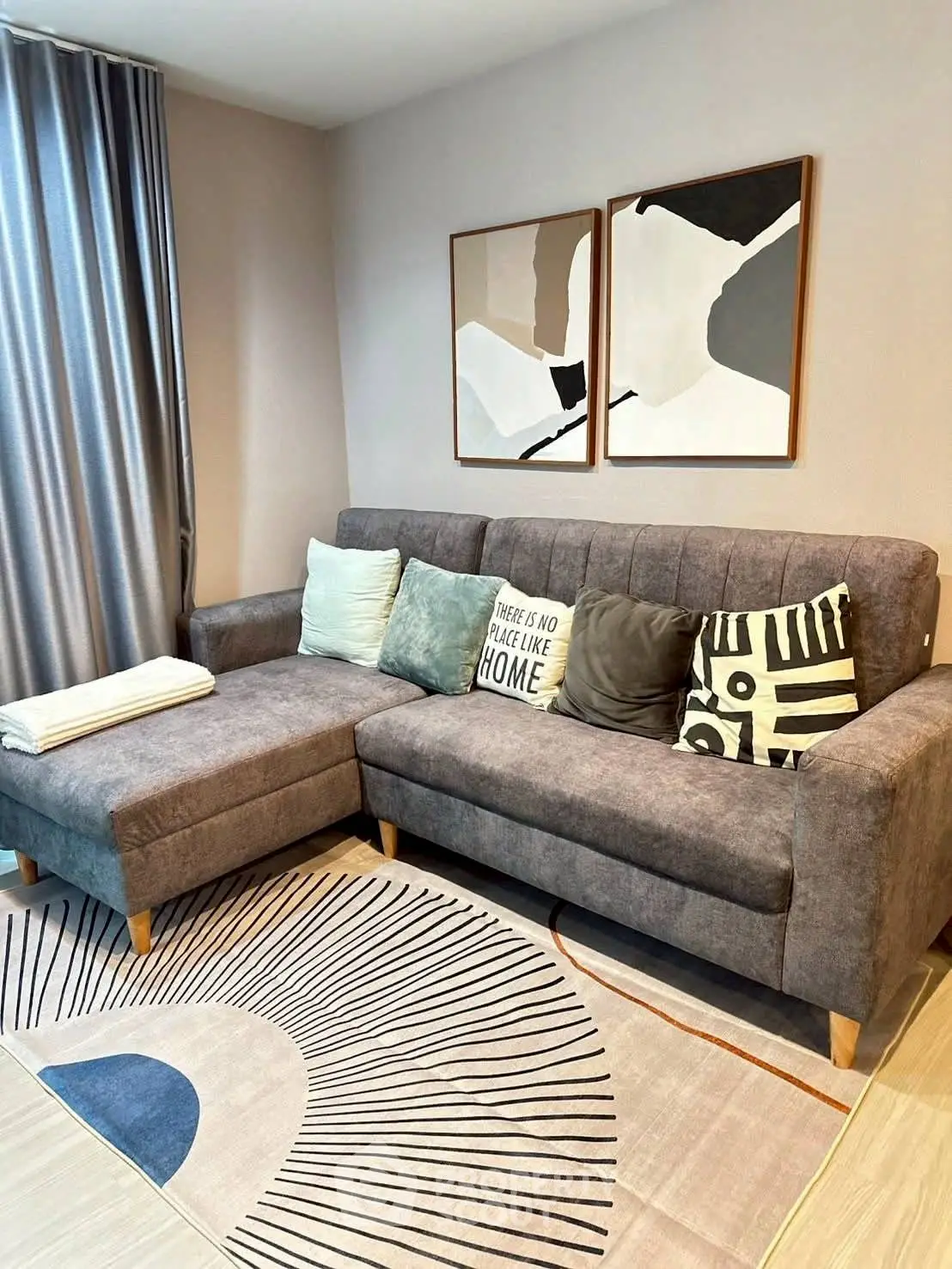 Stylish living room with modern gray sofa and abstract art decor.