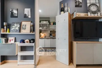 Modern living room with stylish decor and open kitchen layout, featuring sleek cabinetry and contemporary furnishings.