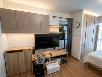 Modern living room with sleek wooden furniture and flat-screen TV, showcasing contemporary interior design.