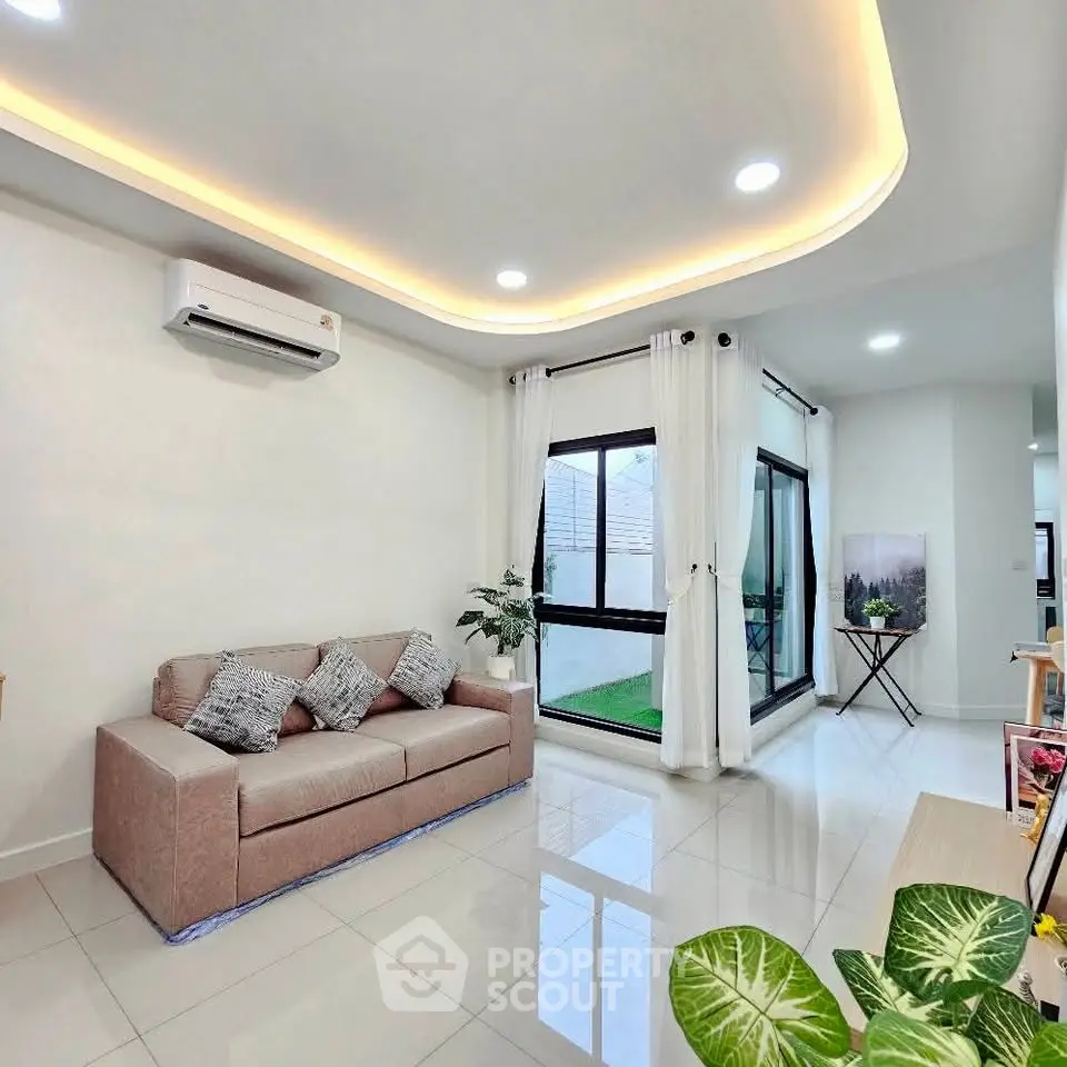 Modern living room with sleek design, featuring a cozy sofa and large windows for natural light.