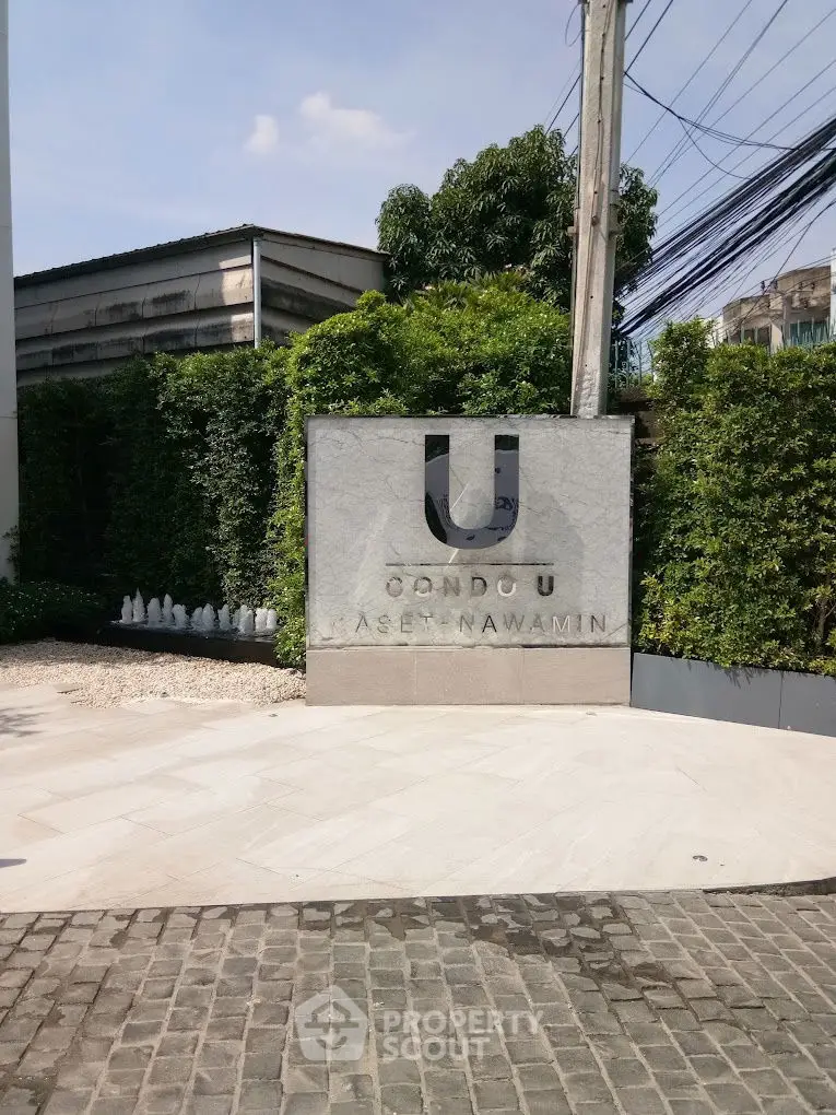Condo U Kaset Nawamin entrance with lush greenery and modern design