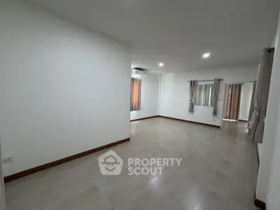 Spacious empty room with tiled flooring and large windows, perfect for customization.