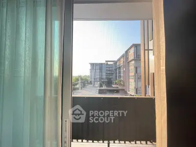 Modern apartment balcony with city view and glass door