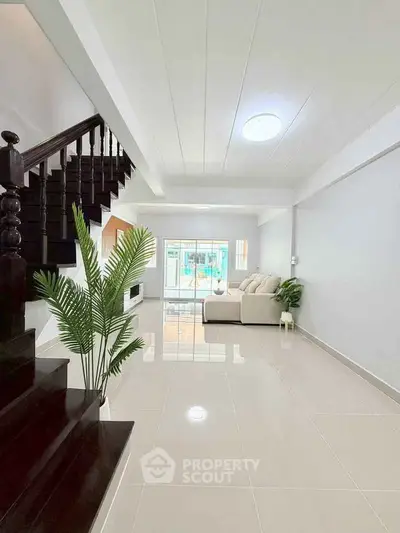 Spacious modern living room with sleek staircase and natural light