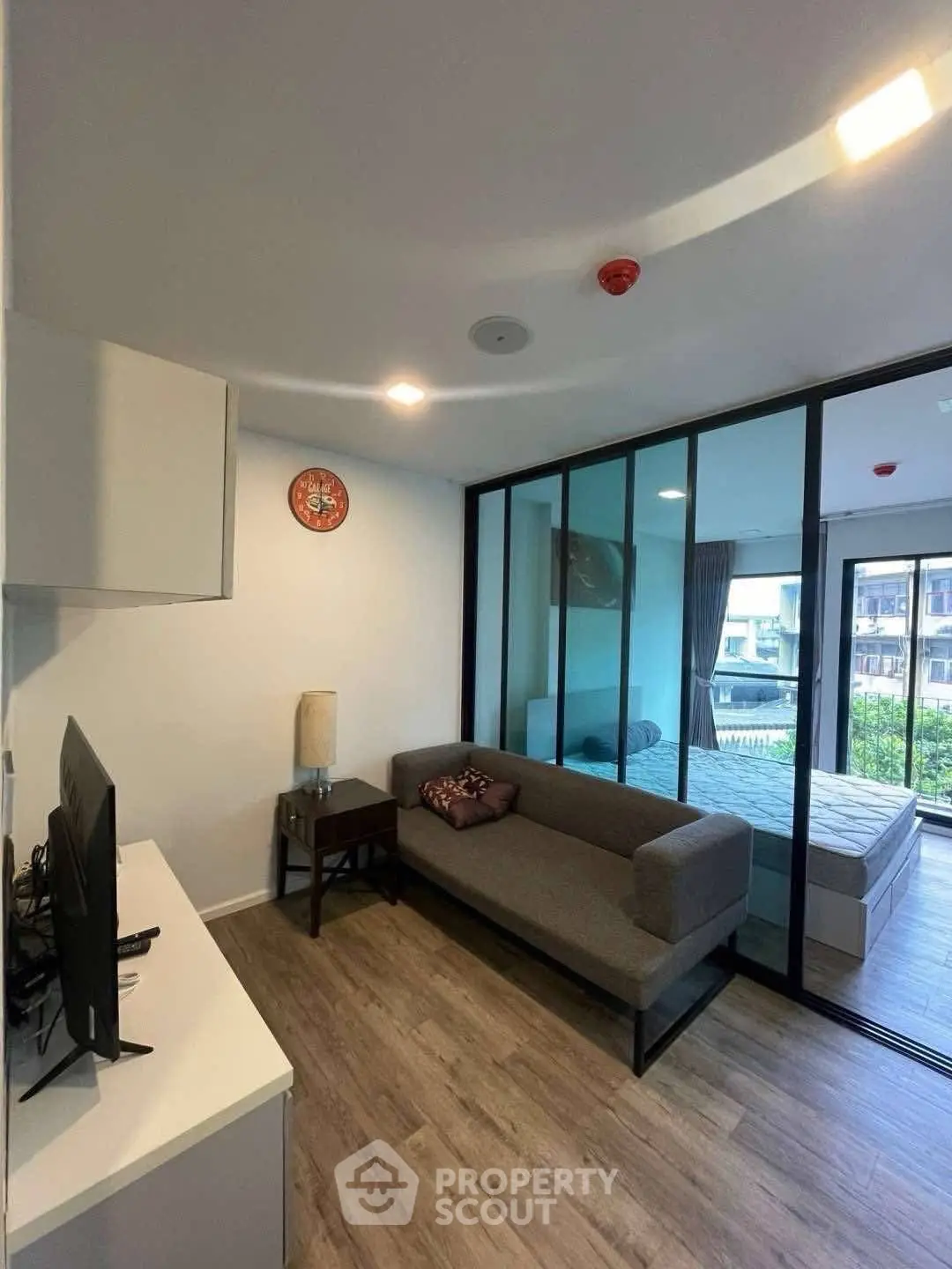 Modern living room with glass partition and cozy decor in a stylish apartment.