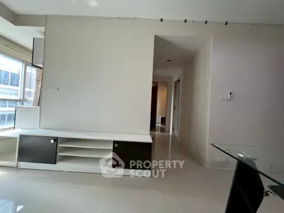 Spacious modern living room with sleek built-in storage and large windows for natural light.