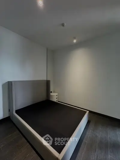 Minimalist bedroom with modern bed frame and sleek flooring, perfect for contemporary living.