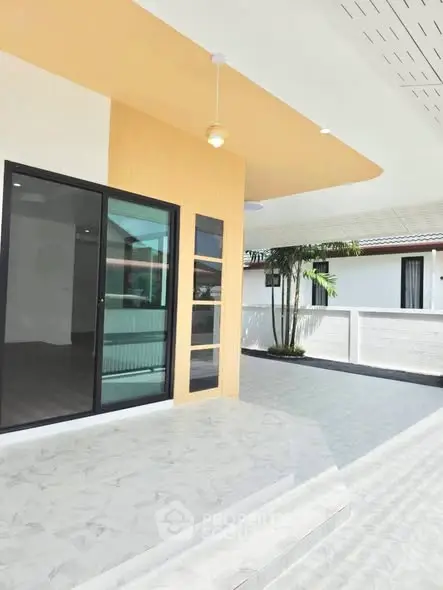 Modern home exterior with spacious patio and sliding glass doors, perfect for outdoor living.