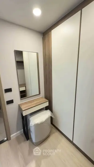 Modern bedroom with sleek wardrobe and stylish vanity in a cozy apartment.