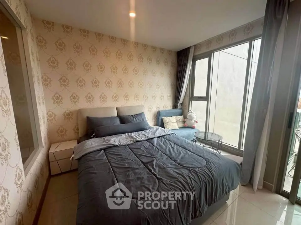 Cozy bedroom with elegant wallpaper and large windows for natural light