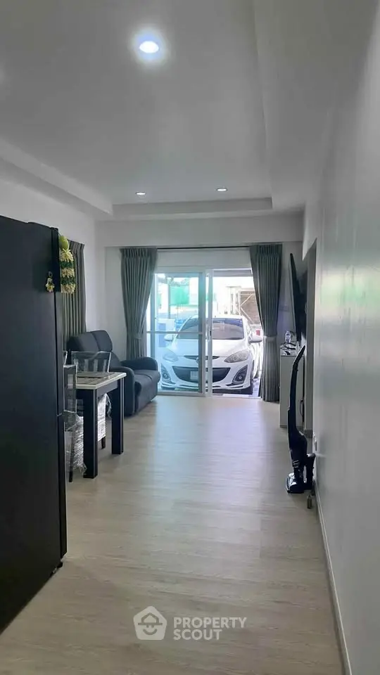 Modern living room with sleek decor and large glass doors leading to a carport.