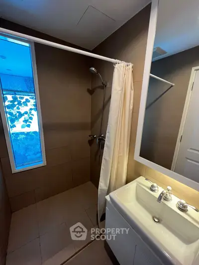 Modern bathroom with sleek shower and stylish sink in contemporary apartment.